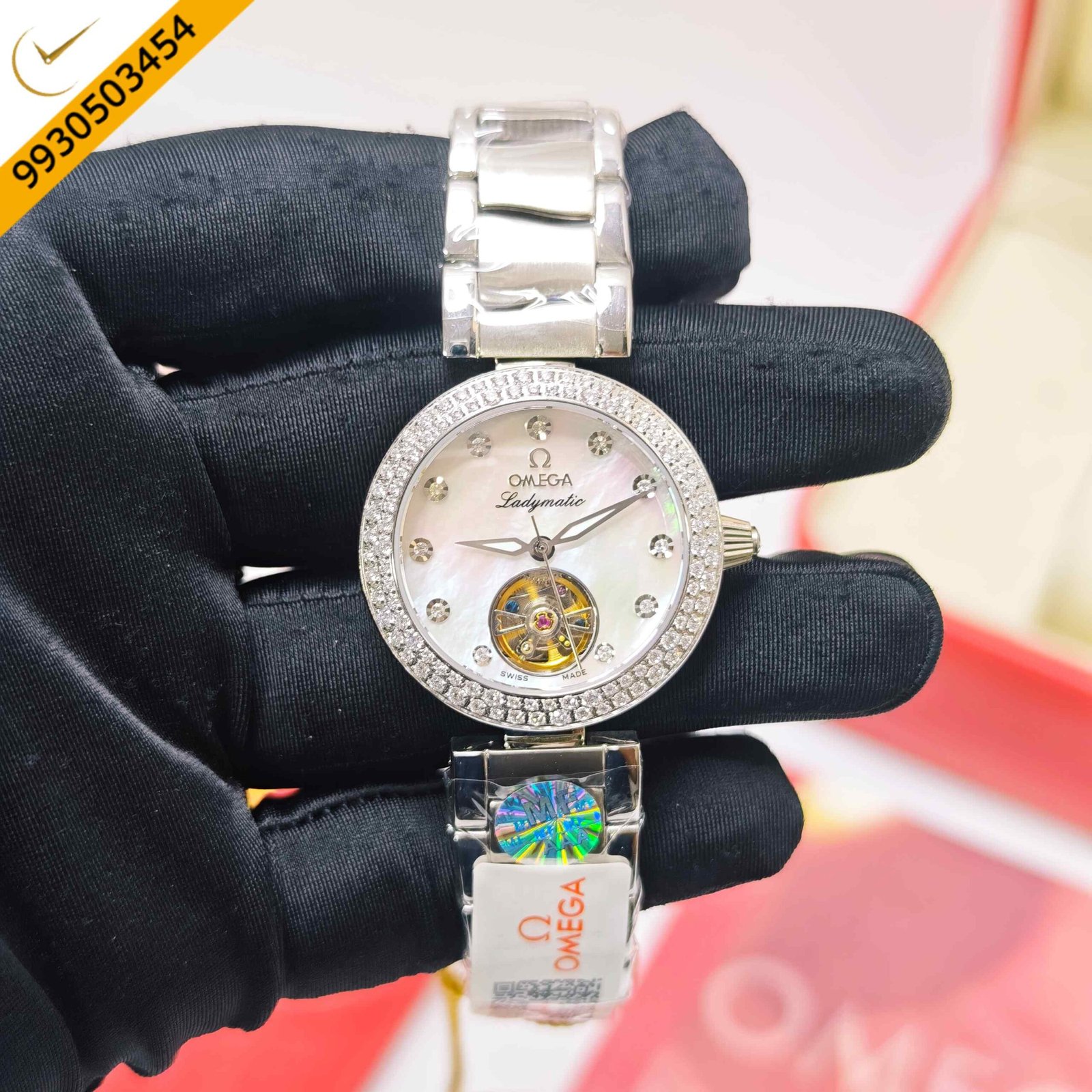 Omega De Ville Ladymatic Tourbillon stainless steel women's automatic watch featuring a white dial with diamond hour markers, Swiss Semi ETA automatic movement, and an elegant luxury dress watch design.